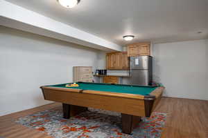 Recreation room with wood finished floors, billiards table, and baseboards