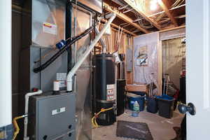 Utilities featuring water heater, heating unit, and electric panel