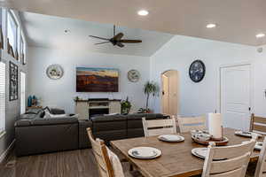 Dining space featuring ceiling fan, arched walkways, lofted ceiling, recessed lighting, and baseboards