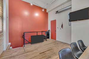 Misc room featuring a high ceiling, wood finished floors, and track lighting
