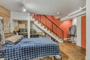 Bedroom with finished concrete flooring and baseboards