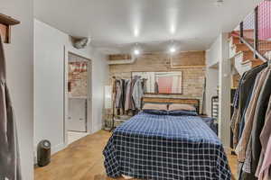 Bedroom featuring rail lighting, baseboards, and concrete floors