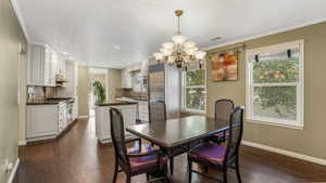 Dining room featuring a chandelier, dark wood-style flooring, baseboards, crown molding, and recessed lighting