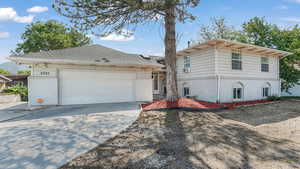 View of front of house featuring concrete driveway, brick siding, and a garage