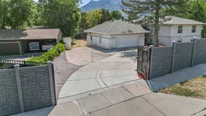 View of front of home with a gate, a mountain view, and a garage