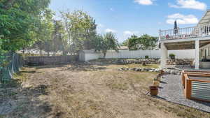 Fenced backyard featuring a patio and a wooden deck