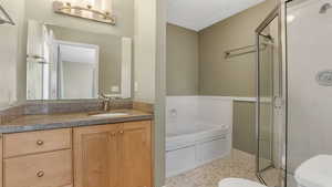 Primary bedroom ensuite bathroom with toilet, a garden tub, vanity, and a shower