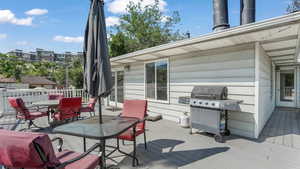 Wooden deck with area for grilling, outdoor dining space, and french doors