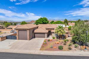 Mediterranean / spanish-style home featuring an attached garage, a gate, stucco siding, a tiled roof, and concrete driveway