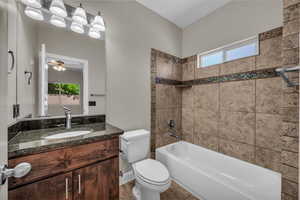 Bathroom featuring vanity, toilet, healthy amount of natural light, and  shower combination