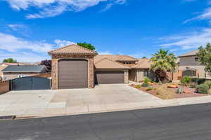 Mediterranean / spanish house featuring a gate, an attached garage, a tile roof, driveway, and stucco siding