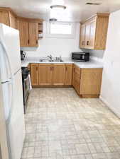 Kitchen with appliances with stainless steel finishes, brick patterned flooring, baseboards, a sink, and open shelves