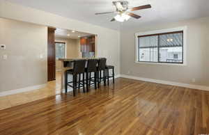 Kitchen featuring light wood-style floors, plenty of natural light, a kitchen breakfast bar, and ceiling fan