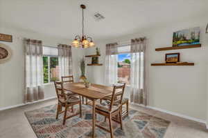 Dining space with plenty of natural light, a chandelier, and light tile patterned floors