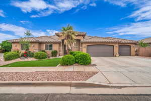 Mediterranean / spanish-style house featuring stucco siding, driveway, a garage, a tiled roof, and a front lawn