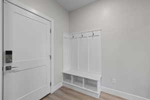 Mudroom near garage featuring built-in bench, cubbies, and coat hooks