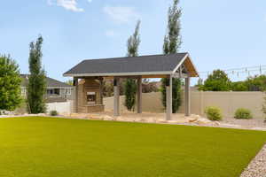 View of backyard featuring custom Timber pergola with fireplace and outdoor lighting, over a Flagstone patio