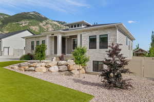 Modern prairie-style home with an attached garage, fenced yard, stone and Hardie side exterior, and heated driveway