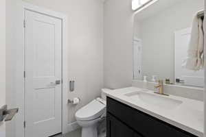 Main floor half bathroom featuring modern style vanity, linen closet, and Toto toilet