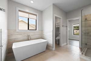 Primary bathroom featuring freestanding soaker tub with tile surround