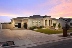 Modern prairie-style home with an attached garage, fenced yard, stone and Hardie side exterior, and heated driveway