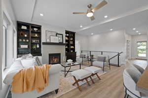 Living area with a tile surround fireplace, built-in cabinetry, LVP flooring, recessed lighting, and natural light.