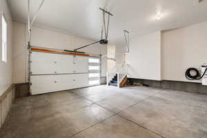 Garage featuring a modern style garage door and opener