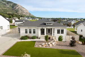 Modern prairie-style home with an attached garage, fenced yard, stone and Hardie side exterior, and heated driveway
