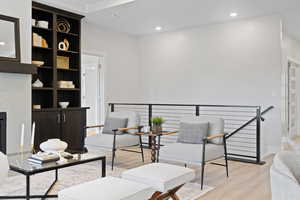 Living area with a tile surround fireplace, built-in cabinetry, LVP flooring, recessed lighting, and natural light.