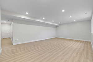 Basement living room featuring LVP flooring and recessed lighting