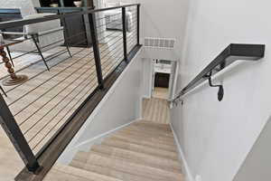 Stairwell featuring LVP flooring and modern style railing.