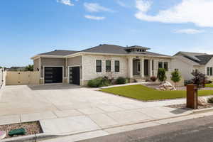 Modern prairie-style home with an attached garage, fenced yard, stone and Hardie side exterior, and heated driveway