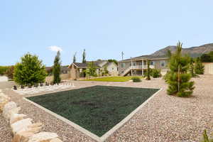 View of backyard play space featuring rubber mulch area for future playset, surrounded by xeriscape landscaping