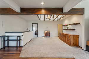 Kitchen with a ceiling fan, beamed ceiling, recessed lighting, open shelves, and electric panel