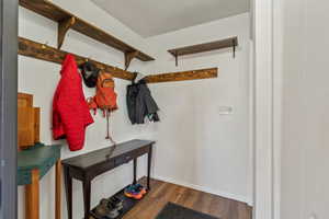Mudroom featuring dark wood-type flooring and baseboards