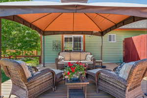 Wooden deck with a gazebo and an outdoor hangout area