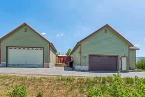 View of side of home featuring a detached garage and an outbuilding