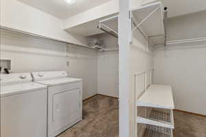 Laundry room featuring carpet floors, washing machine and clothes dryer, and baseboards