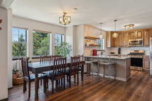 Dining space with a chandelier and dark wood finished floors
