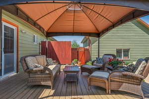 Wooden deck featuring an outdoor hangout area and a gazebo