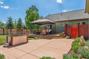 Back of house with a gazebo, a patio area, a shingled roof, and outdoor lounge area
