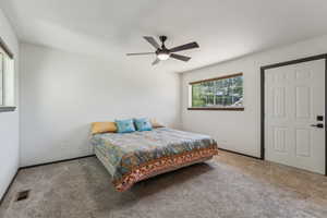 Carpeted bedroom featuring a ceiling fan and baseboards