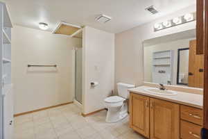 Full bath featuring toilet, vanity, a stall shower, baseboards, and tile patterned flooring