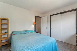 Carpeted bedroom featuring a closet