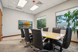 Office with light colored carpet, baseboards, and a drop ceiling