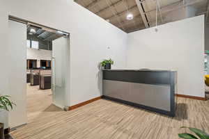 Bar featuring a high ceiling, baseboards, and light colored carpet