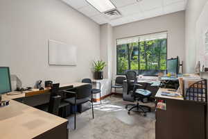 Home office with a paneled ceiling and carpet