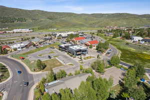 Aerial view of property and surrounding area with a mountain backdrop
