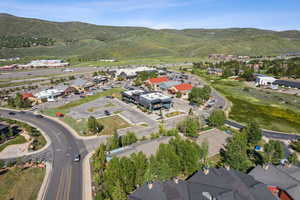 Aerial view of property and surrounding area featuring nearby suburban area and mountains