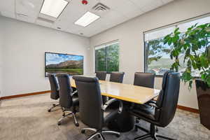 Office space featuring carpet flooring, baseboards, and a drop ceiling